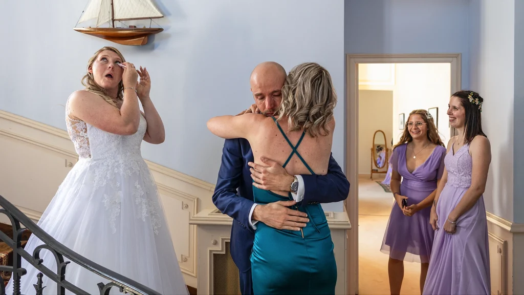 Séquence émotion qui suit le first look. La mariée pleure, le marié serre sa mère dans ses bras sous les yeux de leurs proches.